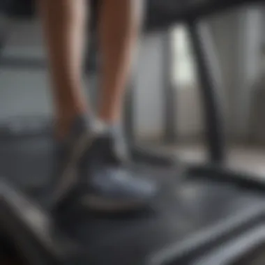 Close-up of a person using a walking treadmill while working on a laptop.